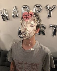 a young man is covered in cake with the words happy new york on it