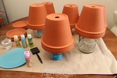 a bunch of clay pots sitting on top of a wooden table next to other items