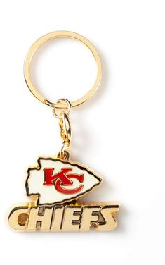 the kansas chiefs logo on a gold keychain is shown in front of a white background