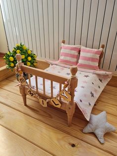 a wooden bed with pink and white pillows on top of it next to a potted plant