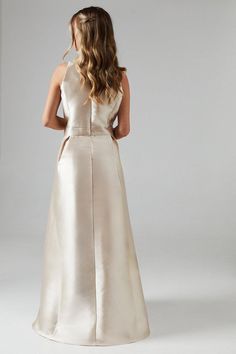 the back of a woman's wedding dress, with her hands on her hips