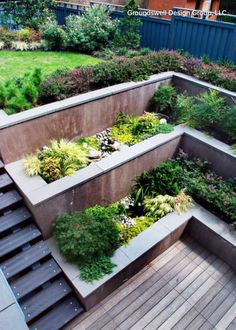 a very nice looking garden with some plants growing in the planter boxes and stairs