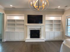 an empty living room with built in bookshelves