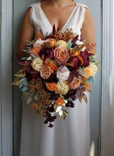 a woman in a white dress holding a large bouquet with flowers on it's side