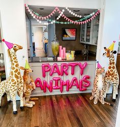 three stuffed giraffes are standing in front of a party animal sign