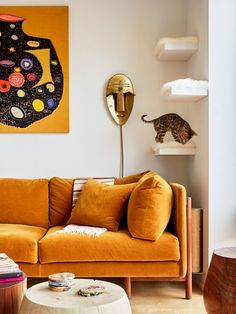 a living room filled with furniture and a cat on the wall