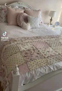 a white bed topped with lots of pillows and blankets