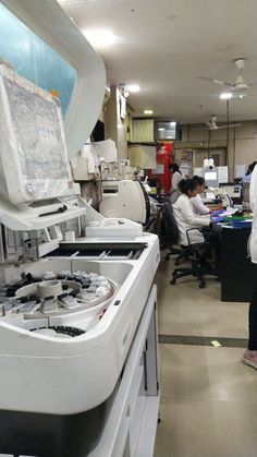 people are working in an office setting with computers and other equipment on the desks