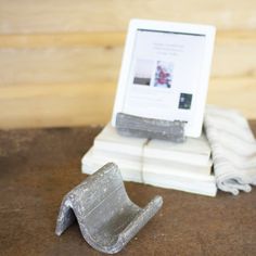 a laptop computer sitting on top of a pile of books next to a white cord