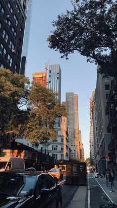 a city street with tall buildings and cars parked on the side of the road in front of them