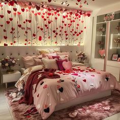 a bedroom decorated in pink and red with hearts on the bed