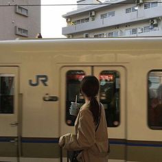 a woman is waiting for the train to arrive