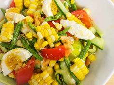 a white bowl filled with vegetables and hard boiled eggs