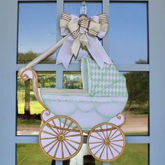 a baby's carriage hanging on the side of a window in front of a blue door