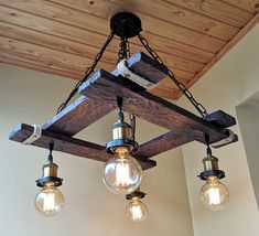 three light bulbs hanging from a wooden beam