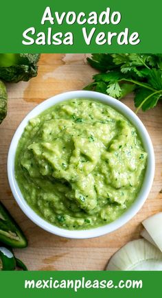 avocado salsa in a white bowl with cilantro on the side