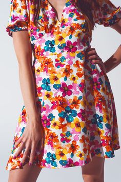 Delve into the boho chic style with our Short Dress with Cinched Waist in Multicolor Floral Print. The dress is constructed from 100% Polyester, assuring a lightweight feel and longevity. The model, standing at 5'8'' with measurements of 33-24-35, wears a size S and the dress runs true to size. Its regular fit coupled with an elasticated back offers a figure-hugging cut, accentuating your curves perfectly. The mini length and the vivacious floral print make this dress a standout for casual and f Multicolor V-neck Floral Dress With Vibrant Print, Colorful Floral Print V-neck Dress, Flowy A-line Mini Dress With Floral Print, Spring Floral V-neck Dress With Vibrant Print, Flowy A-line Floral Dress, Floral Print A-line Sundress For Garden Party, Chic Multicolor A-line Floral Dress, Vibrant Floral Print V-neck Mini Dress, Mini Length Ditsy Floral Print Vacation Dress