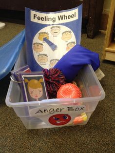 a plastic container filled with toys sitting on top of a carpeted floor next to a sign