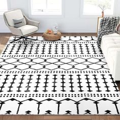 a black and white rug in the middle of a living room with a couch, chair and ottoman