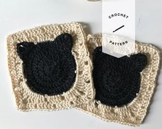 two crocheted coasters with black cats on them, one is white and the other is beige