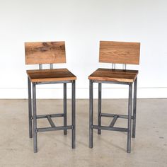 two wooden chairs sitting side by side next to each other