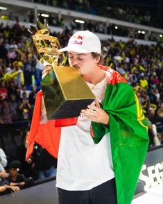 a young man holding up a trophy in front of a crowd at a sporting event