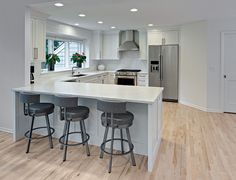 a kitchen with two stools and an island