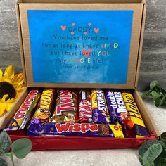 a box filled with candy next to a sunflower