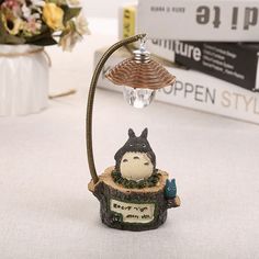 a figurine with a lamp on top of it sitting on a table next to some books