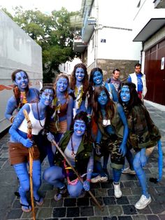 a group of people with blue paint on their faces and body are posing for the camera