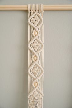 a macrame beaded bracelet hanging on a wall