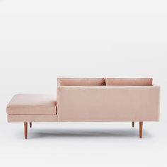 a pink couch sitting on top of a white floor