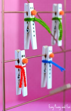 popsicle snowmen are hanging on the clothes pins