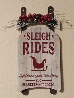 a wooden sign hanging from the side of a wall next to a red and white christmas decoration