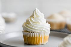 a cupcake with white frosting on a plate