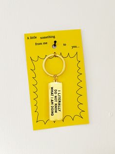 a keychain hanging on the side of a white wall with a yellow background