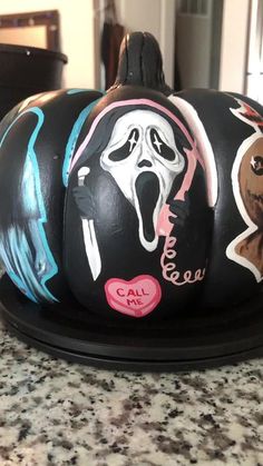 a decorated pumpkin sitting on top of a counter next to a black plate with stickers