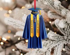 a blue graduation gown ornament hanging from a christmas tree