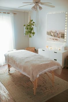 a white bed sitting on top of a rug in a bedroom next to a window