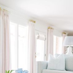 a living room filled with white furniture and blue vases on top of a coffee table