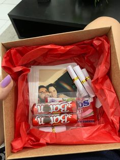 a person holding a box with some candy in it and two photos on the inside