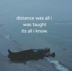 a man laying on the beach with his head in the water and text that reads, distance was all i was taught it's all i know