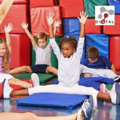 children sitting on the floor with their arms in the air while they are doing yoga