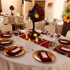 the table is set with place settings for dinner and wine glasses, plates, and napkins