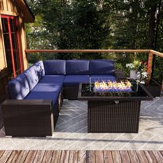 a couch and table on a deck with fire pit in the middle for relaxing time