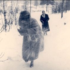 two women walking through the snow in winter