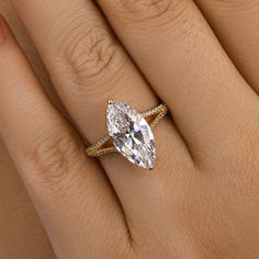 a woman's hand with a ring on it and a pear shaped diamond in the middle