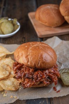 a pulled pork sandwich with chips on the side