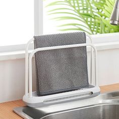 a kitchen sink with a towel rack next to it and a window in the background