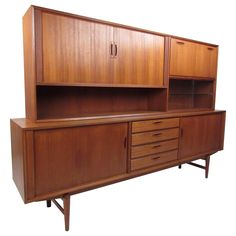 a large wooden cabinet with drawers and cupboards on the top, against a white background